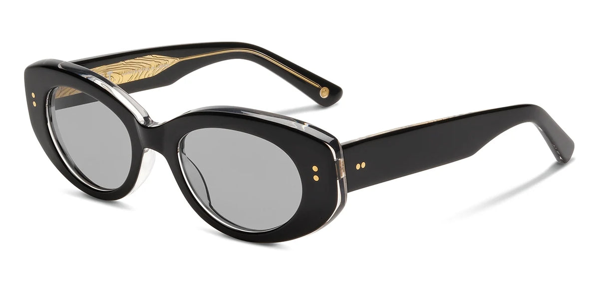 The SALT. Cass sunglasses by SALT. feature a black oval frame crafted from premium Japanese acetate, accented with silver rims and gray polarized optical lenses for superior clarity and comfort. Gold detailing adorns the arms, including a wavy pattern on the inside and two small gold dots near the hinges.