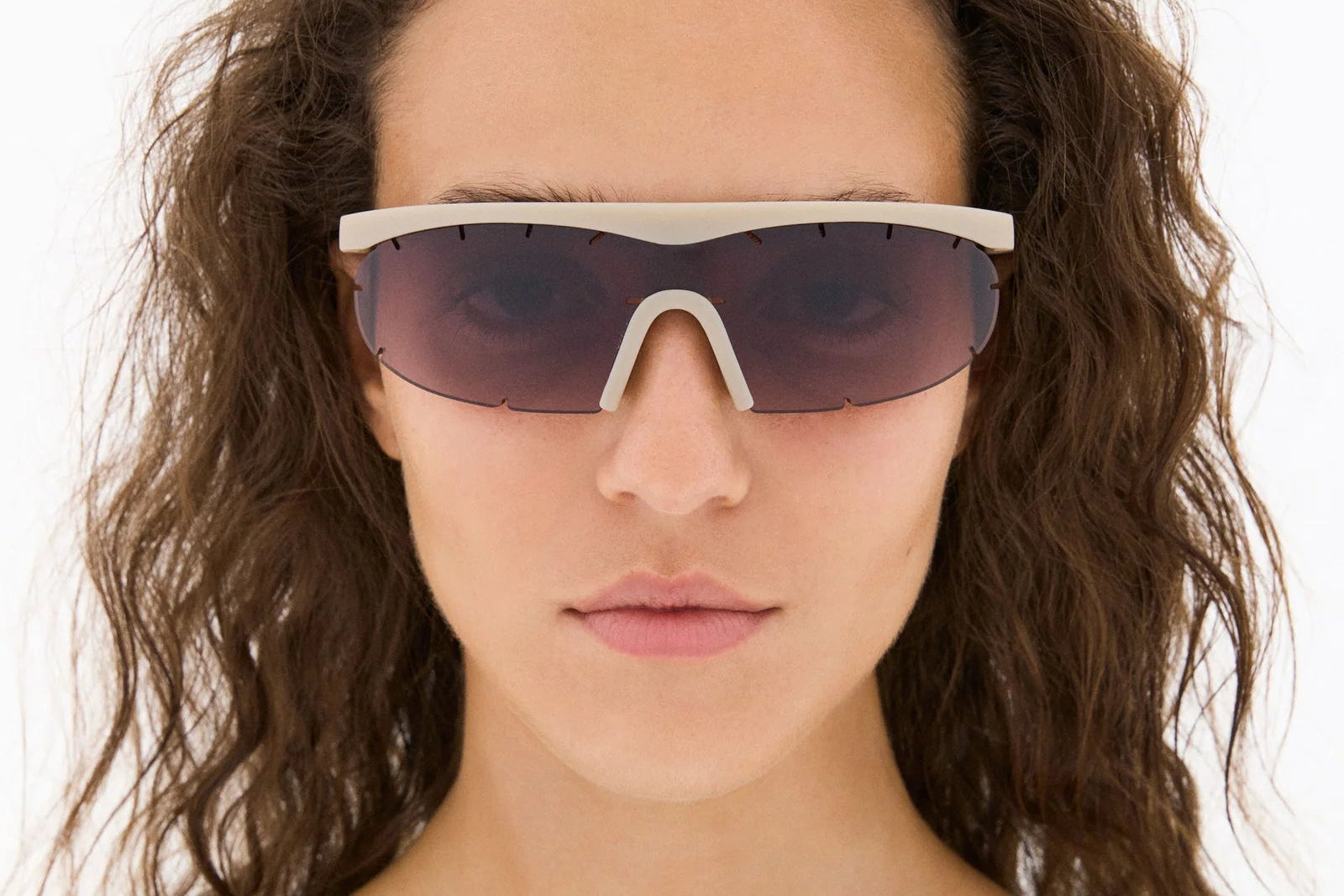 Woman wearing futuristic sunglasses with a white background