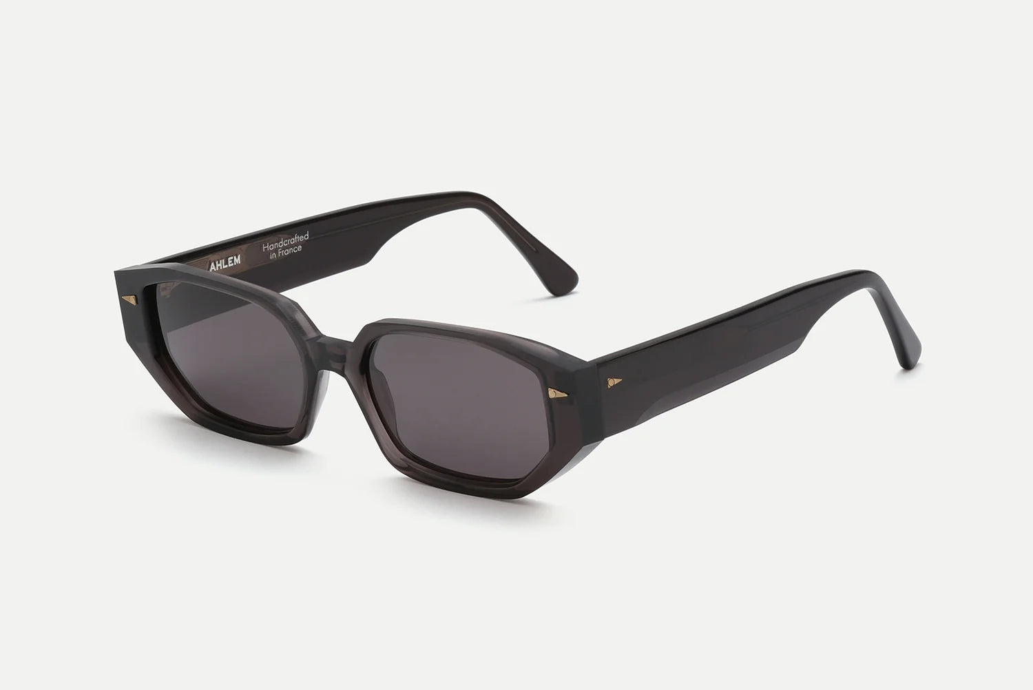 AHLEM Poitou sunglasses by AHLEM are black, rectangular-shaped eyewear with thick frames and dark lenses, showcased against a plain white background. Handcrafted in France from premium Italian acetate, these sunglasses feature wide temples and subtle 22k gold hardware accents near the hinges, offering a touch of refined elegance.