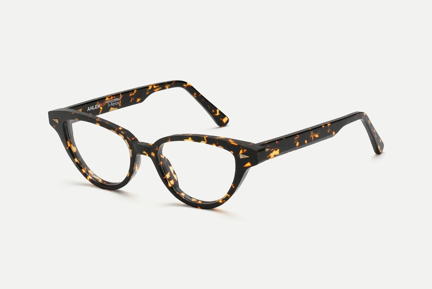 AHLEM Lilas cat-eye optical glasses by AHLEM, featuring brown and amber tortoiseshell thick frames, handcrafted in France from premium plant-based Italian acetate, shown on a plain white background.