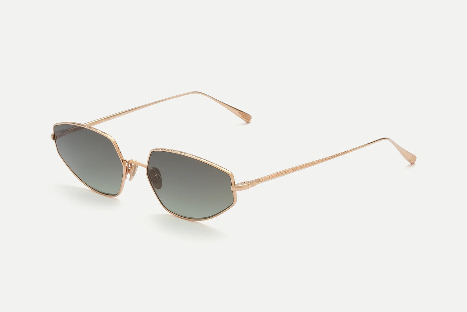 AHLEM Yvonne sunglasses by AHLEM, featuring gold frames with geometric cat-eye shaped dark lenses and thin arms, handcrafted in France and inspired by Bauhaus design, displayed on a white background.