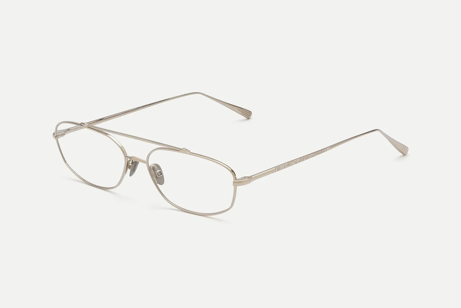 A pair of slim metal eyeglasses with a thin silver-tone frame and clear lenses, shown at an angle on a light gray background.
