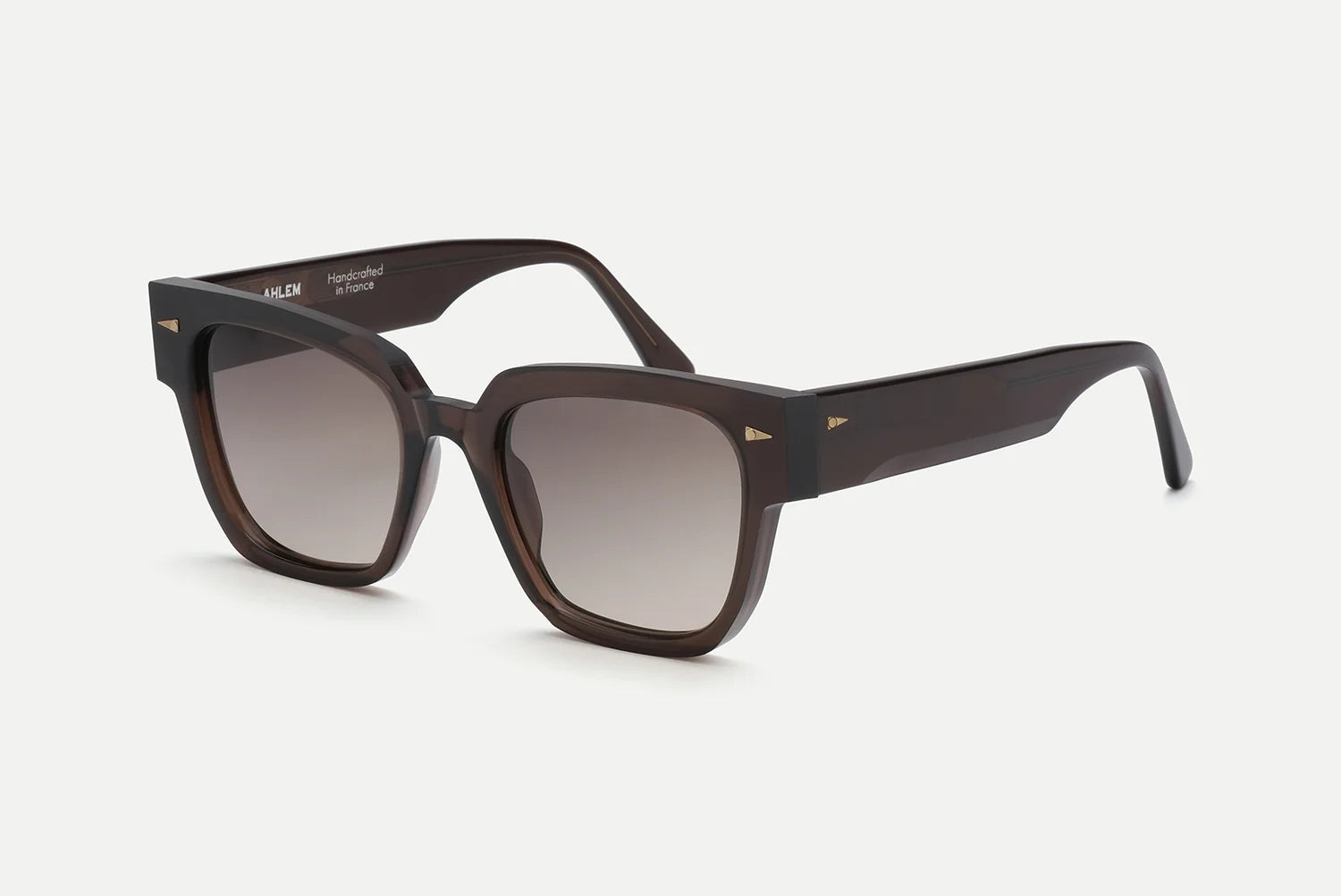 AHLEM Italiens sunglasses by AHLEM—a pair of dark brown, square handcrafted French sunglasses with thick frames and gradient lenses, displayed on a light background. The temples are adorned with a delicate gold accent near the hinges for an elegant finishing touch.