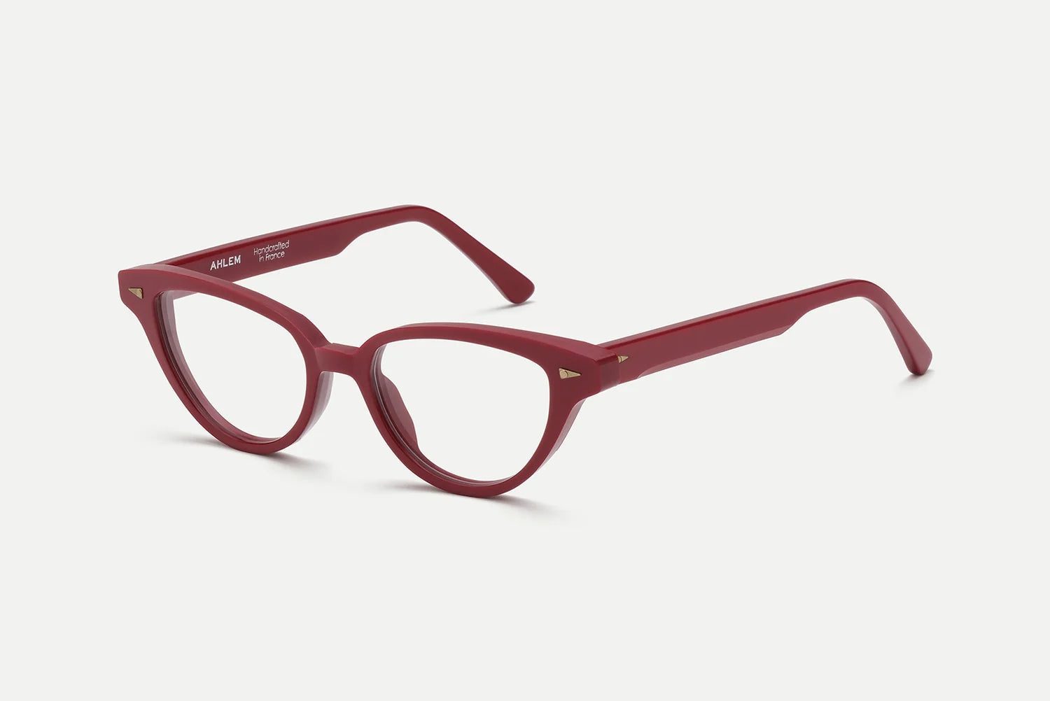 AHLEM Lilas cat-eye optical glasses with clear lenses, displayed at an angle against a plain white background. The bold, glossy frames are handcrafted in France by AHLEM from plant-based Italian acetate and feature subtle metallic accents at the front corners.