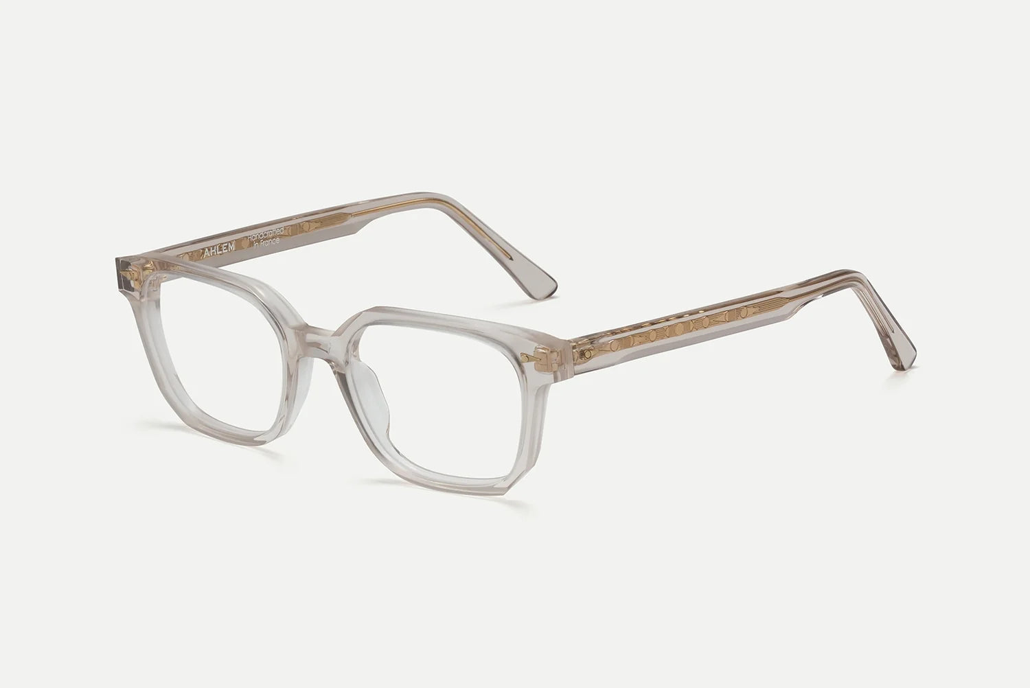 AHLEM Houdon by AHLEM, clear rectangular optical glasses with thick transparent frames and brown-tinted temples featuring premium steel hardware, are displayed on a white background.