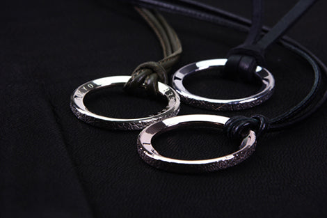 Silver ring necklace on a dark background