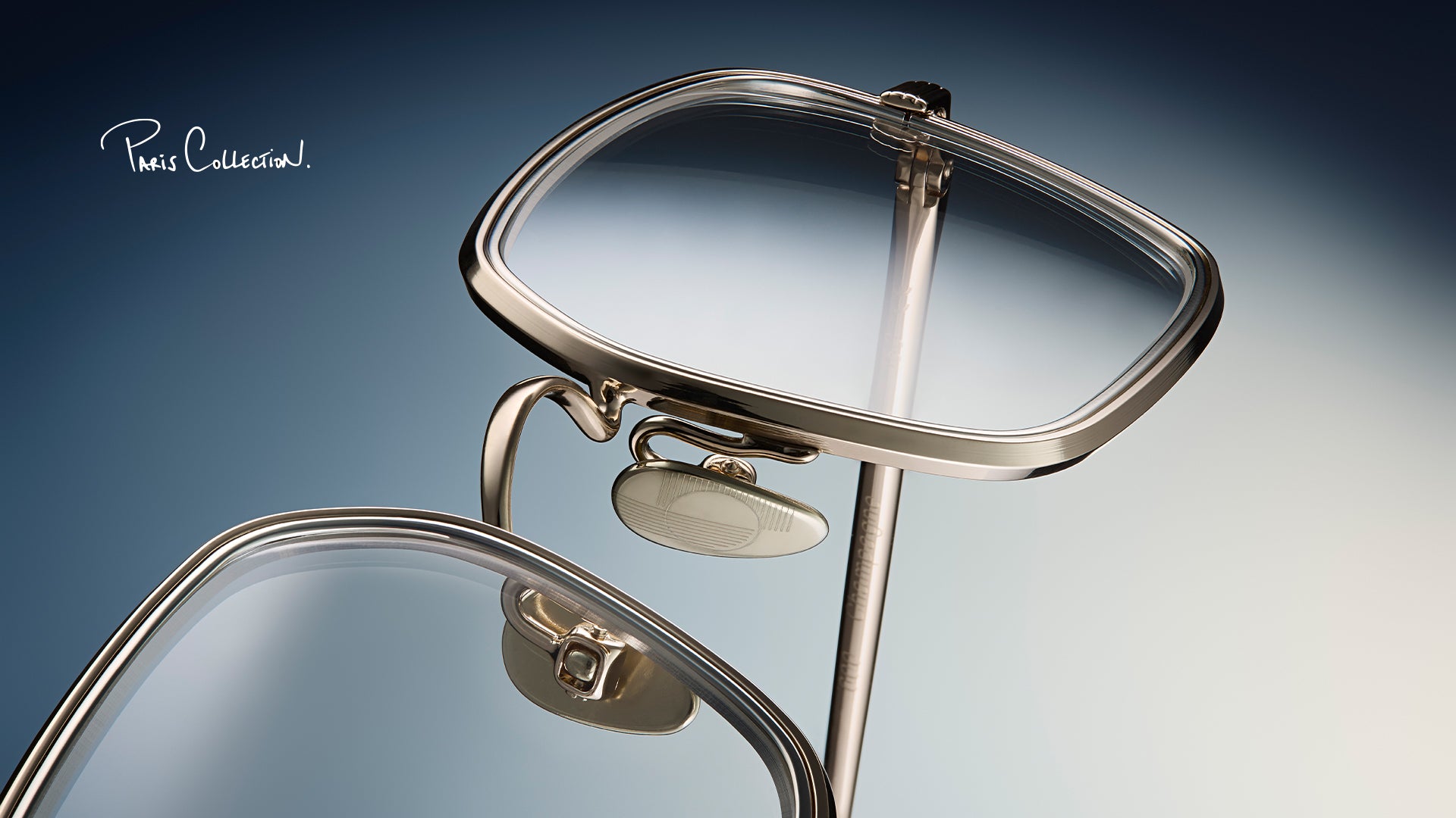 Close-up of AHLEM PARIS EYEWEAR COLLECTION with a mirror on a gradient blue and gray background.