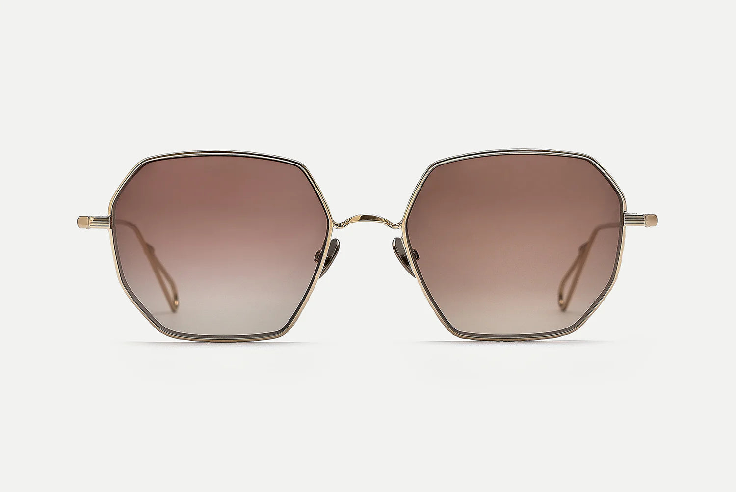 Sunglasses with gold frame and brown gradient lenses on a white background