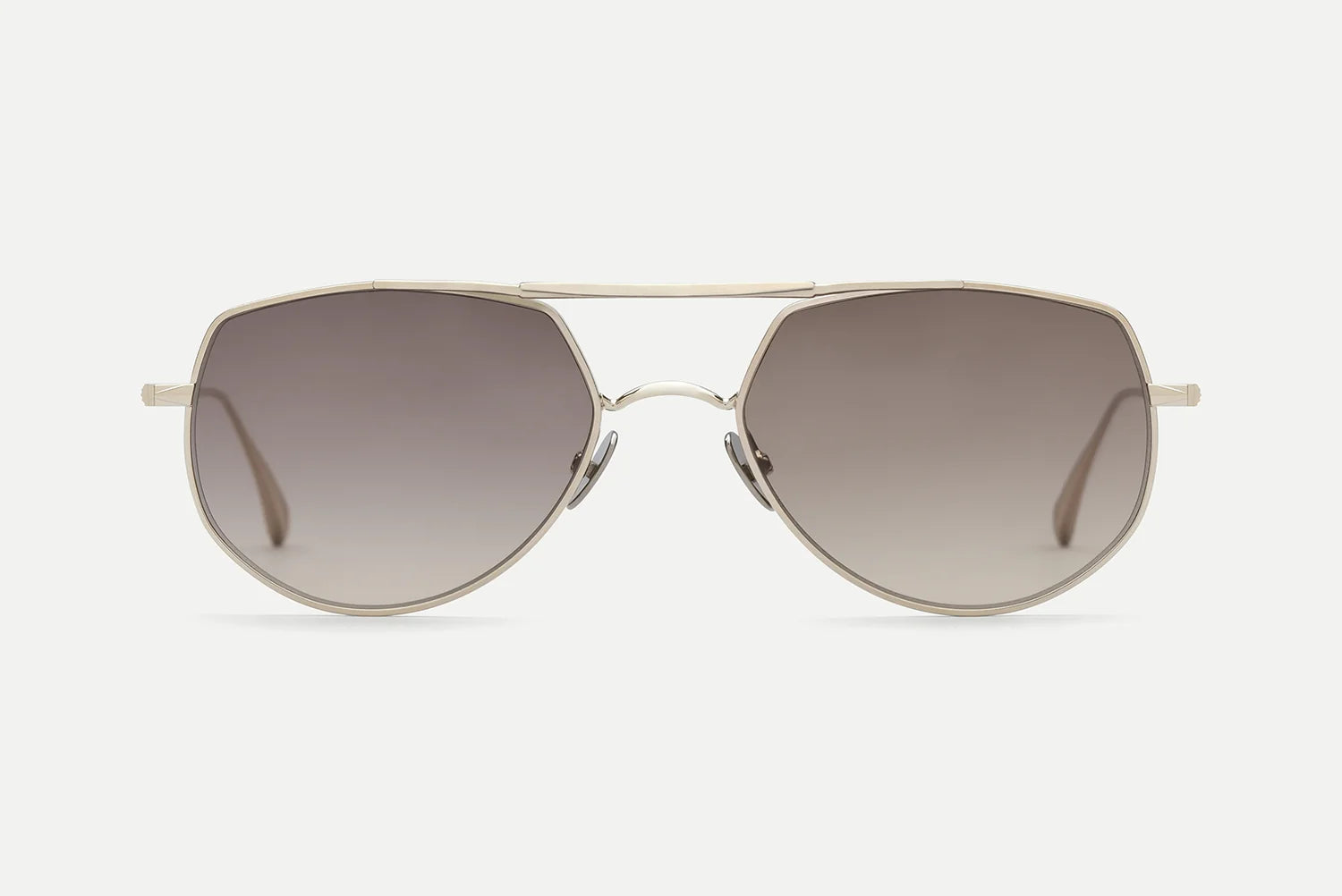 A pair of aviator-style sunglasses with a thin gold metal frame and gradient brown lenses, shown against a light gray background.