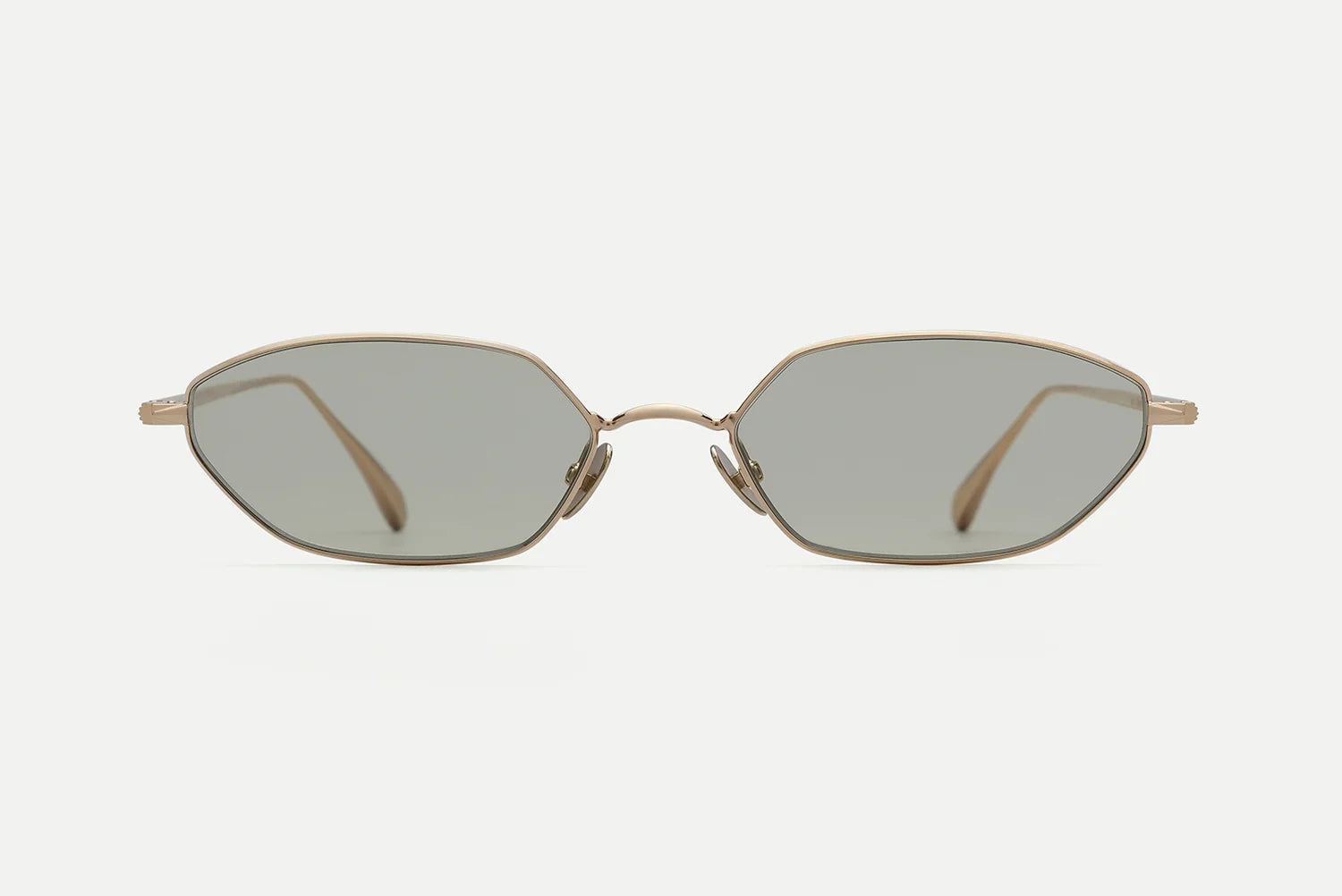 AHLEM Iris sunglasses by AHLEM, handcrafted in France with gold metal frames, feature irregular hexagonal gray tinted lenses and are shown from the front on a plain white background.