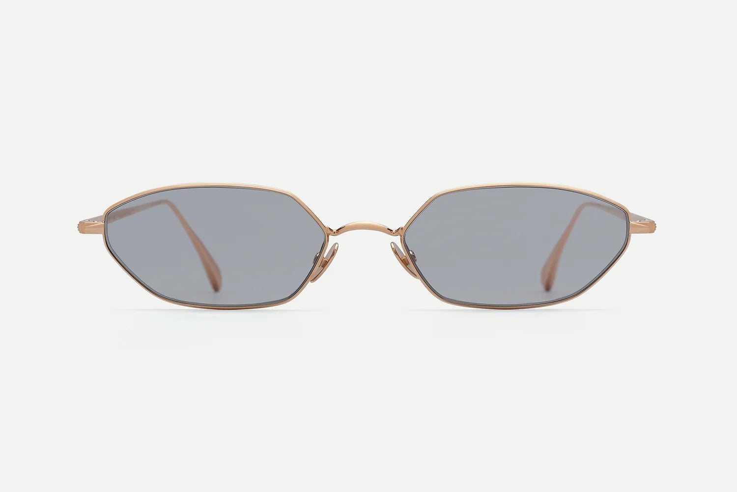 AHLEM Iris sunglasses by AHLEM, handcrafted in France from luxurious 22k gold, feature gold frames with thin arms and dark hexagonal lenses. Displayed on a white background with the front of the frames facing forward.