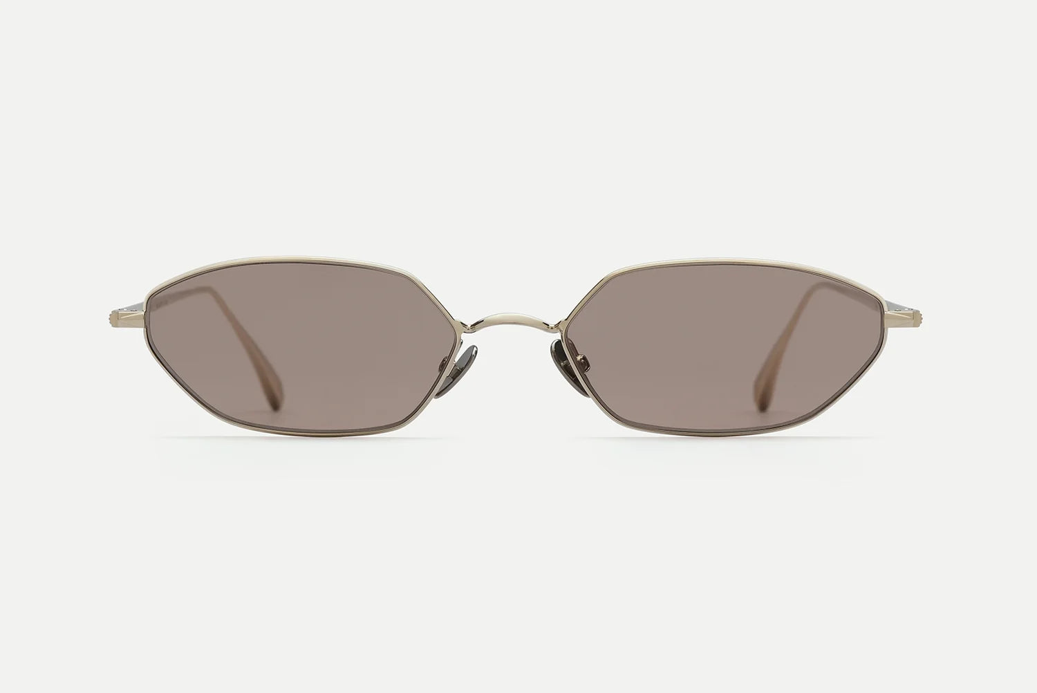 AHLEM Iris sunglasses by AHLEM, handcrafted in France, featuring thin 22k gold metallic frames and brown-tinted hexagonal lenses, shown on a white background and viewed from the front.