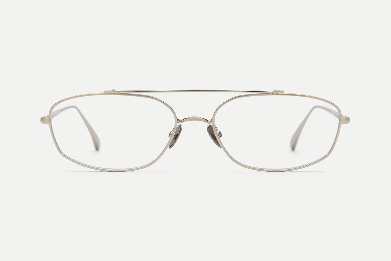 A pair of slim metal eyeglasses with a double bridge and a thin, slightly rounded rectangular frame, shown against a plain light gray background.