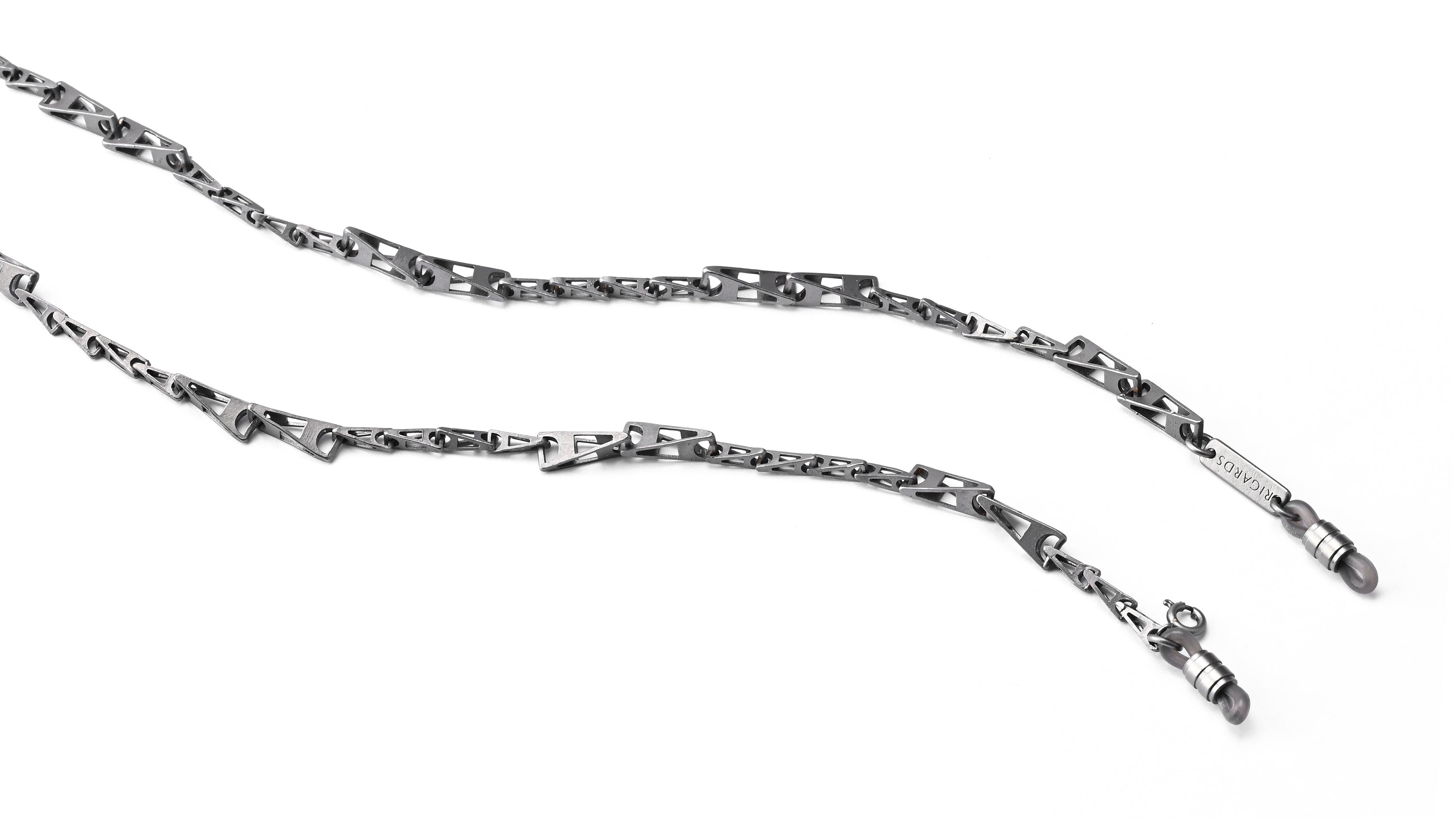 A silver-toned metal link chain necklace with a distinctive cutout pattern and a lobster clasp closure, displayed on a clean white background.
