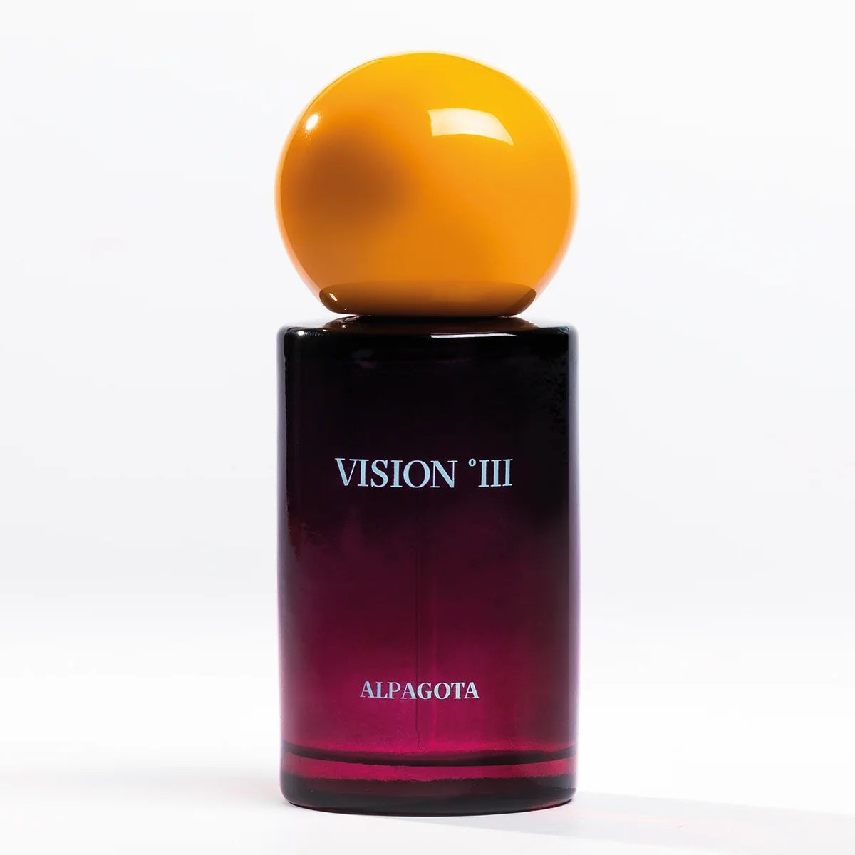 Vision III Alpagota perfume bottle with a glossy dark purple gradient glass body, white lettering, and a large spherical amber-yellow cap, set against a plain white background.