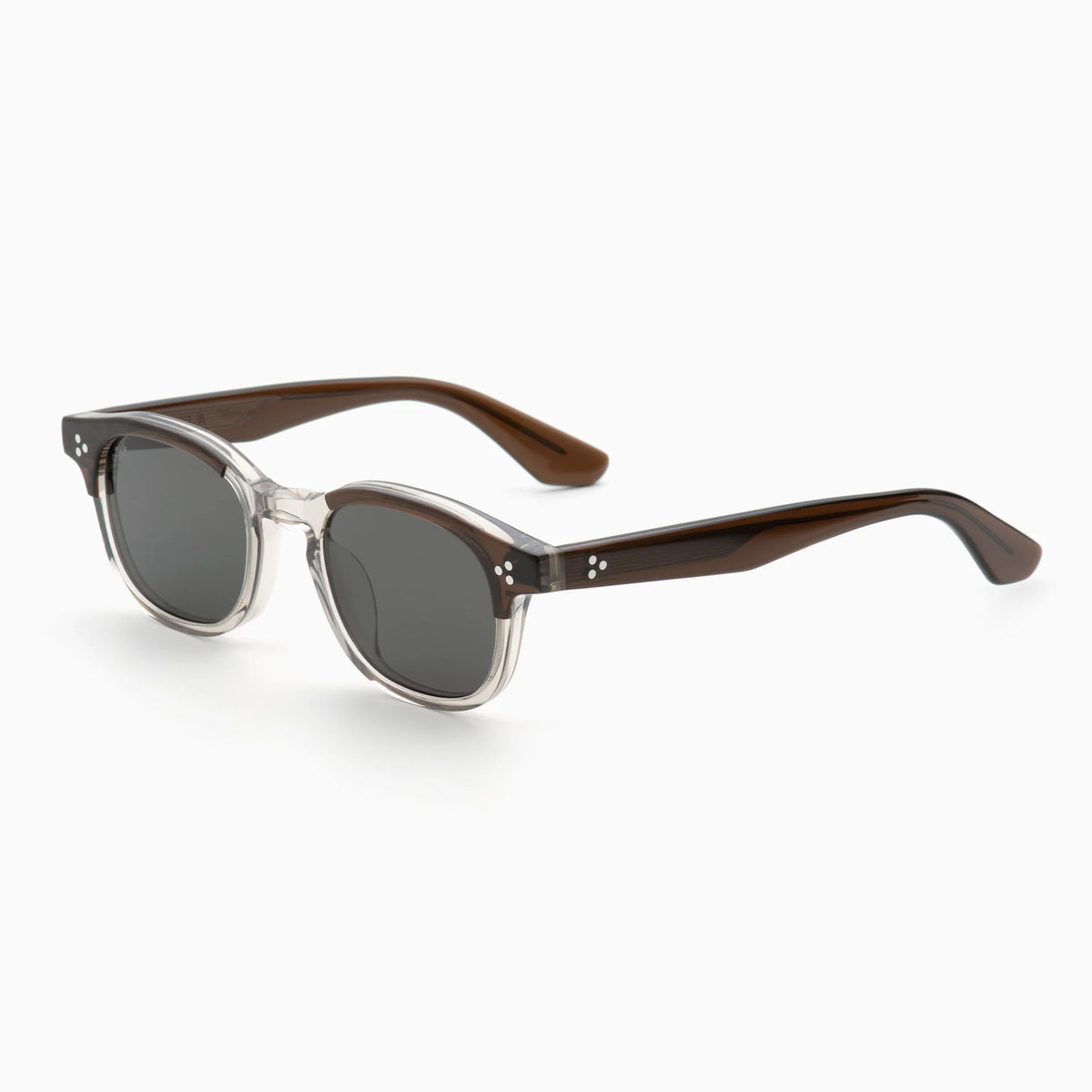 The Akila Atria sunglasses by Akila feature a versatile round silhouette with clear frames in the front and dark brown arms. Designed for a medium fit, they include dark lenses and subtle silver dot accents near the hinges, all showcased against a plain white background.