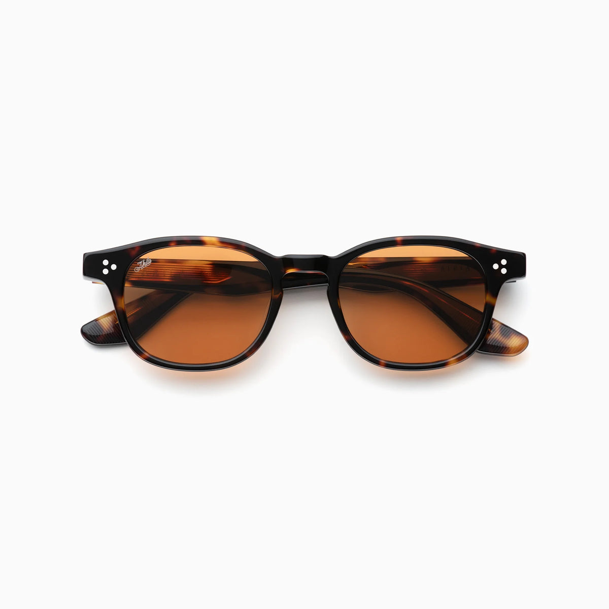 The Akila Atria sunglasses by Akila feature round tortoiseshell frames with brown lenses and two small silver dots on each side of the front. Designed with a balanced silhouette and medium fit, these sunglasses have slightly curved arms for a touch of subtle style. Displayed against a white background.