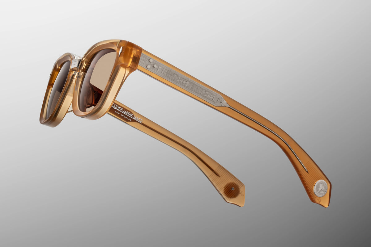 Jacques Marie Mage Yellowstone VII: Barronette In Brush sunglasses in translucent amber handcrafted plant-based acetate, featuring etched silver temple detailing and brown polarized mineral glass lenses.