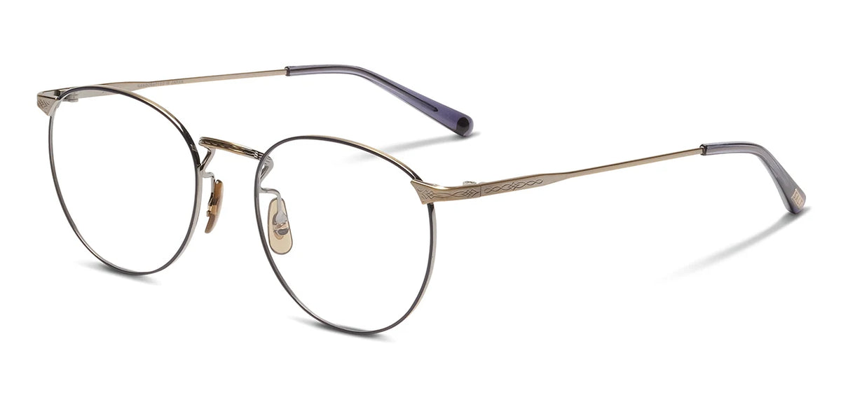 The SALT. Brower eyeglasses by SALT. feature ultra-lightweight, round frames crafted from hypoallergenic Japanese titanium in a refined gold finish. Adjustable nose pads and dark plastic temple tips provide comfort, while the thin metal arms are accented with a subtle engraved pattern near the hinges.
