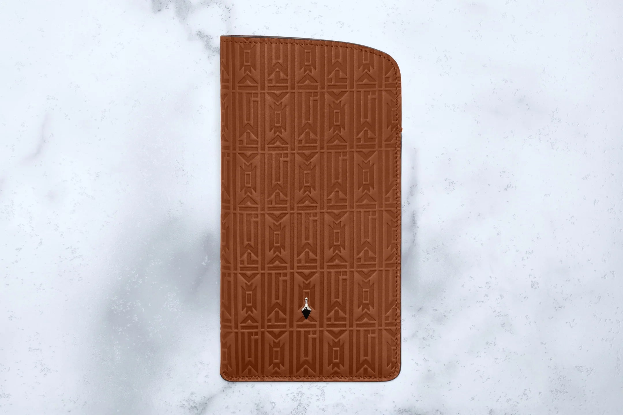 Brown embossed wallet on a light gray marble background