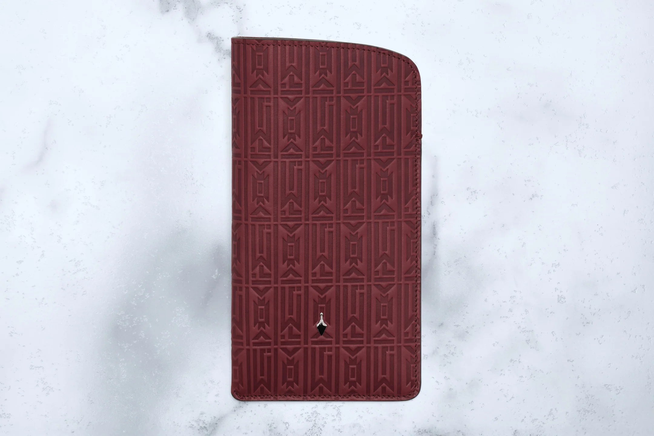 Maroon phone case with geometric pattern on a light gray background