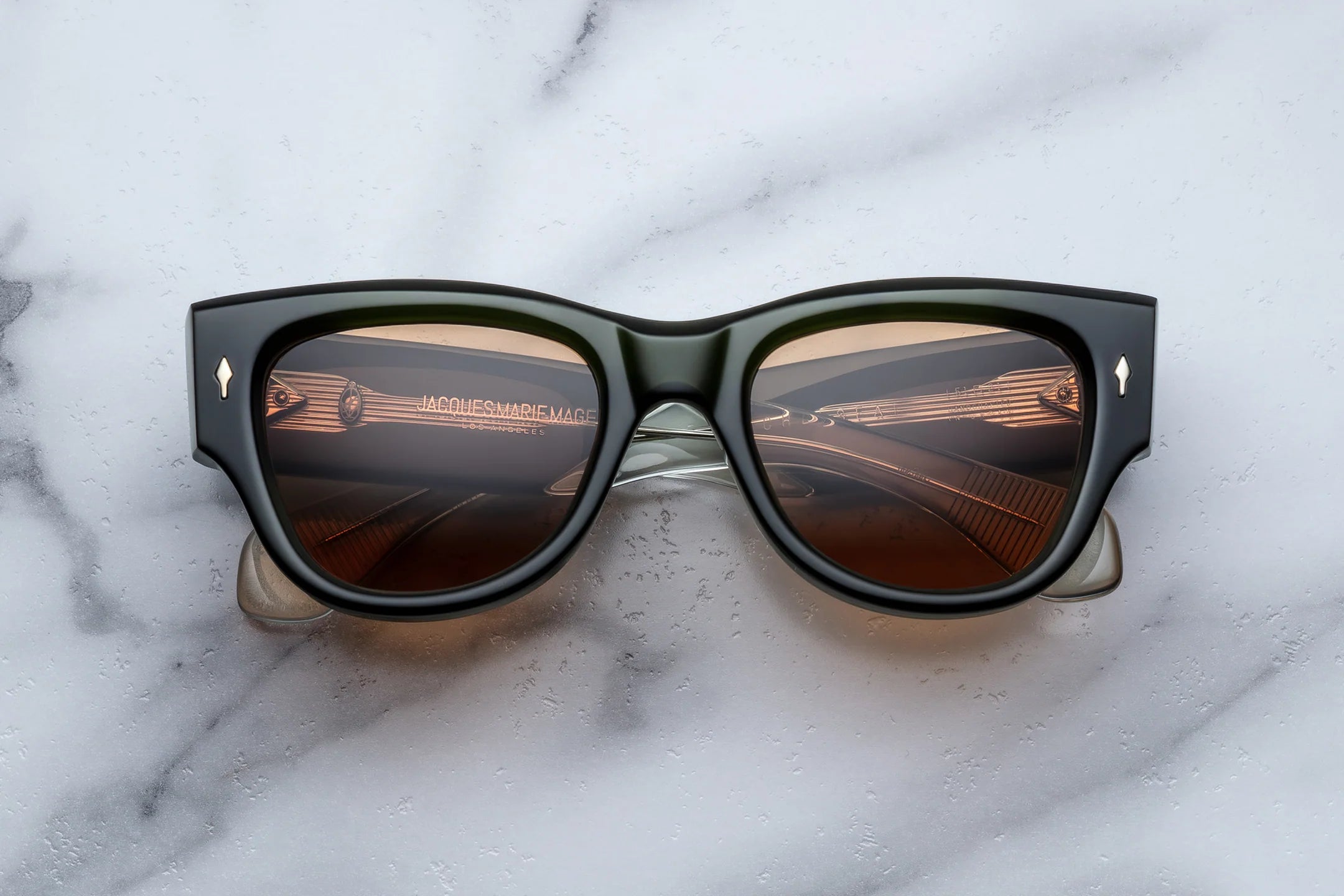 Sunglasses with reflective lenses on a marble surface