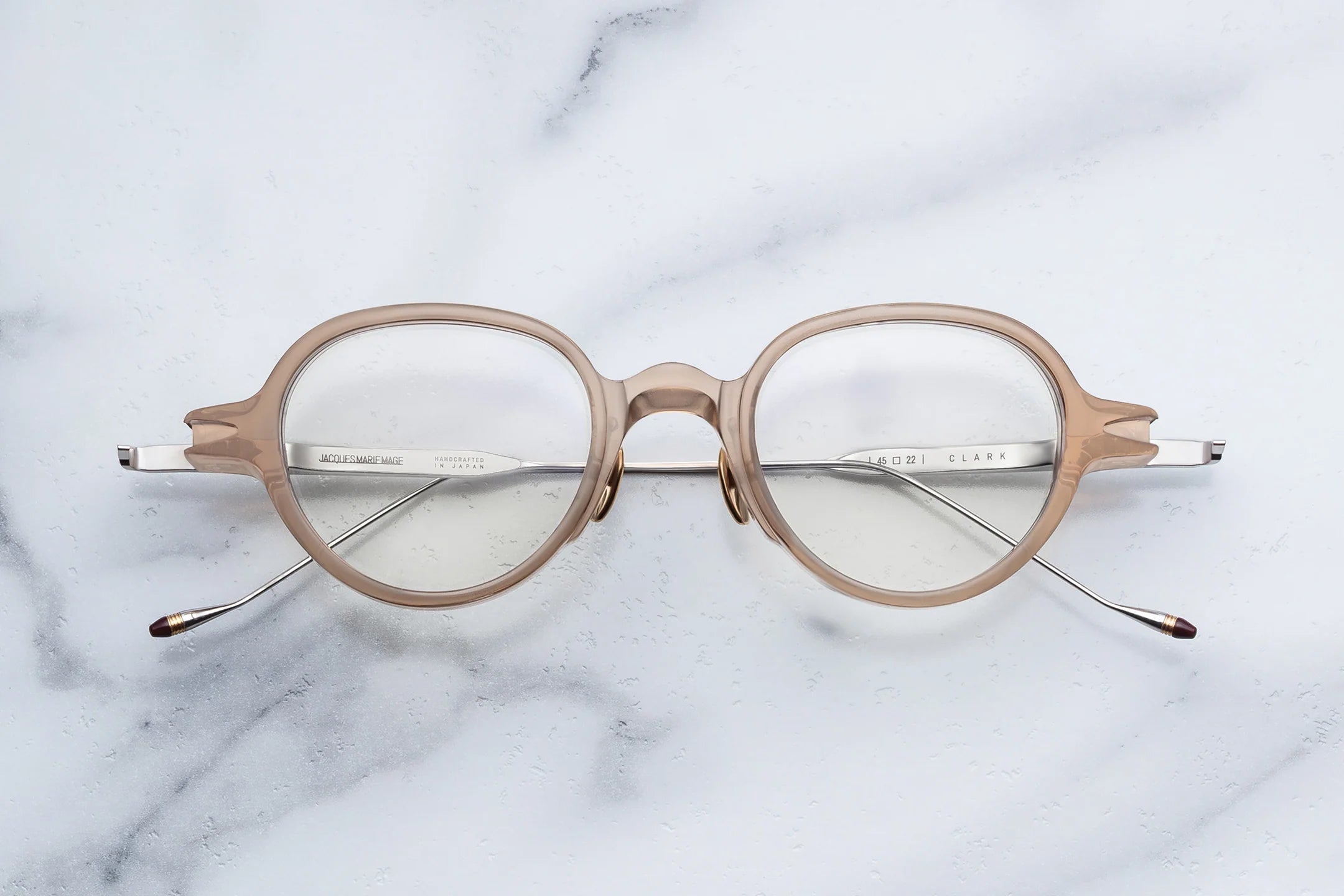 Round eyeglasses on a marble surface