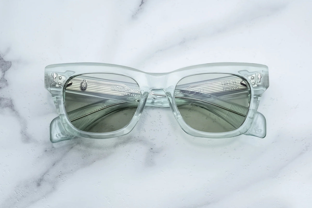 Jacques Marie Mage Dealan clear-framed glasses with gray custom photochromic lenses and visible interior silver temple hardware.