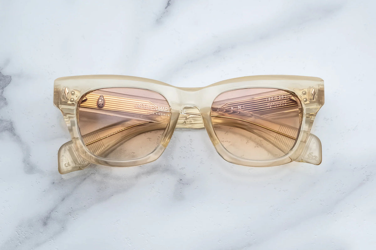 Jacques Marie Mage Dealan translucent champagne-colored rectangular photochromic sunglasses with gradient peach-tinted lenses.