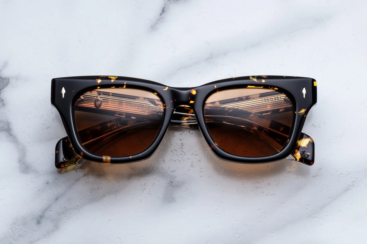 Jacques Marie Mage Dealan tortoiseshell-patterned rectangular sunglasses with dark tinted lenses and gold metal accents at the temples, channeling ’60s style.