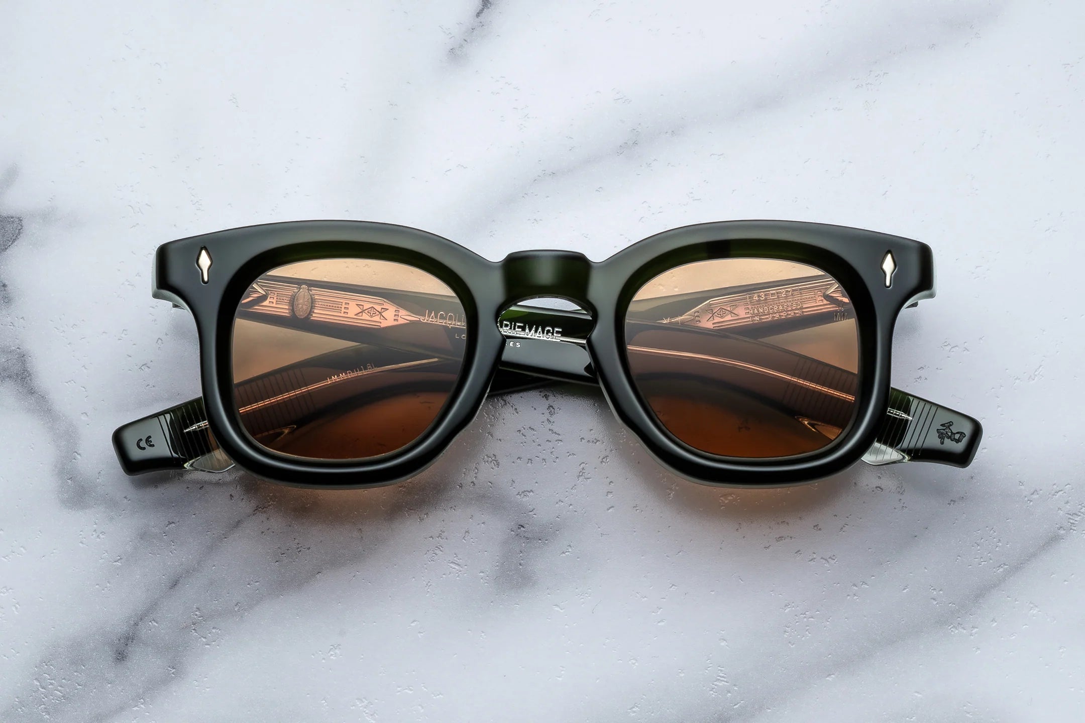 Black sunglasses with brown lenses on a marble surface