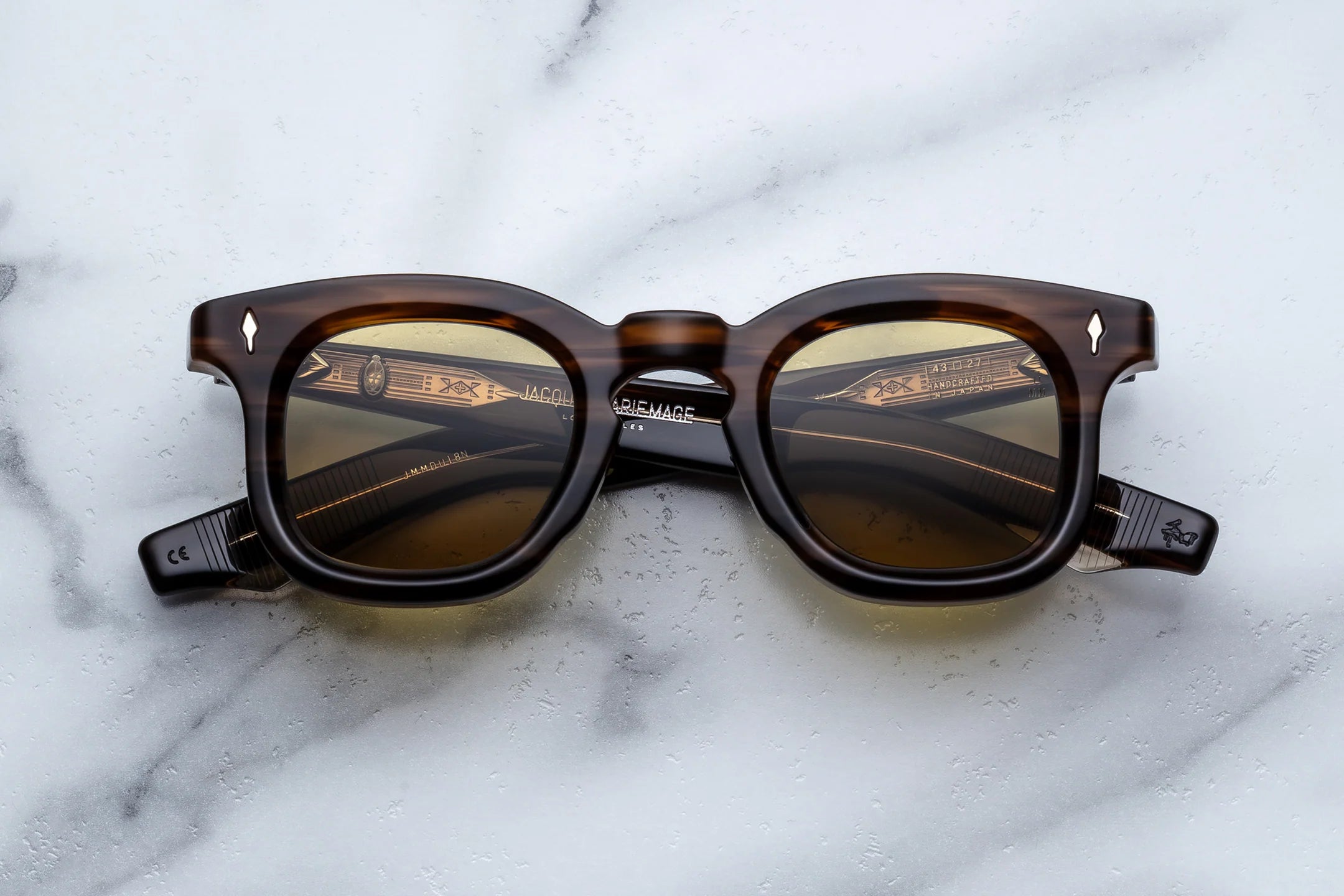 Brown sunglasses with reflective lenses on a marble surface
