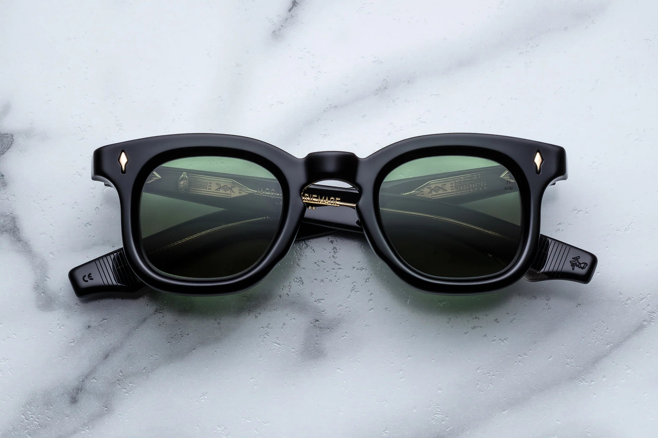 Black sunglasses with reflective lenses on a marble surface