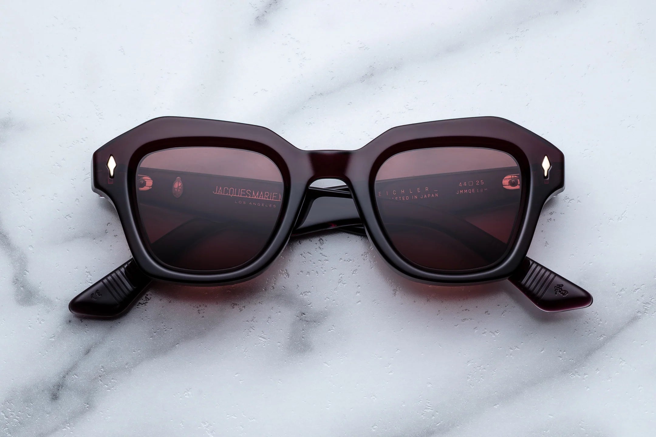 Sunglasses with dark lenses on a marble surface