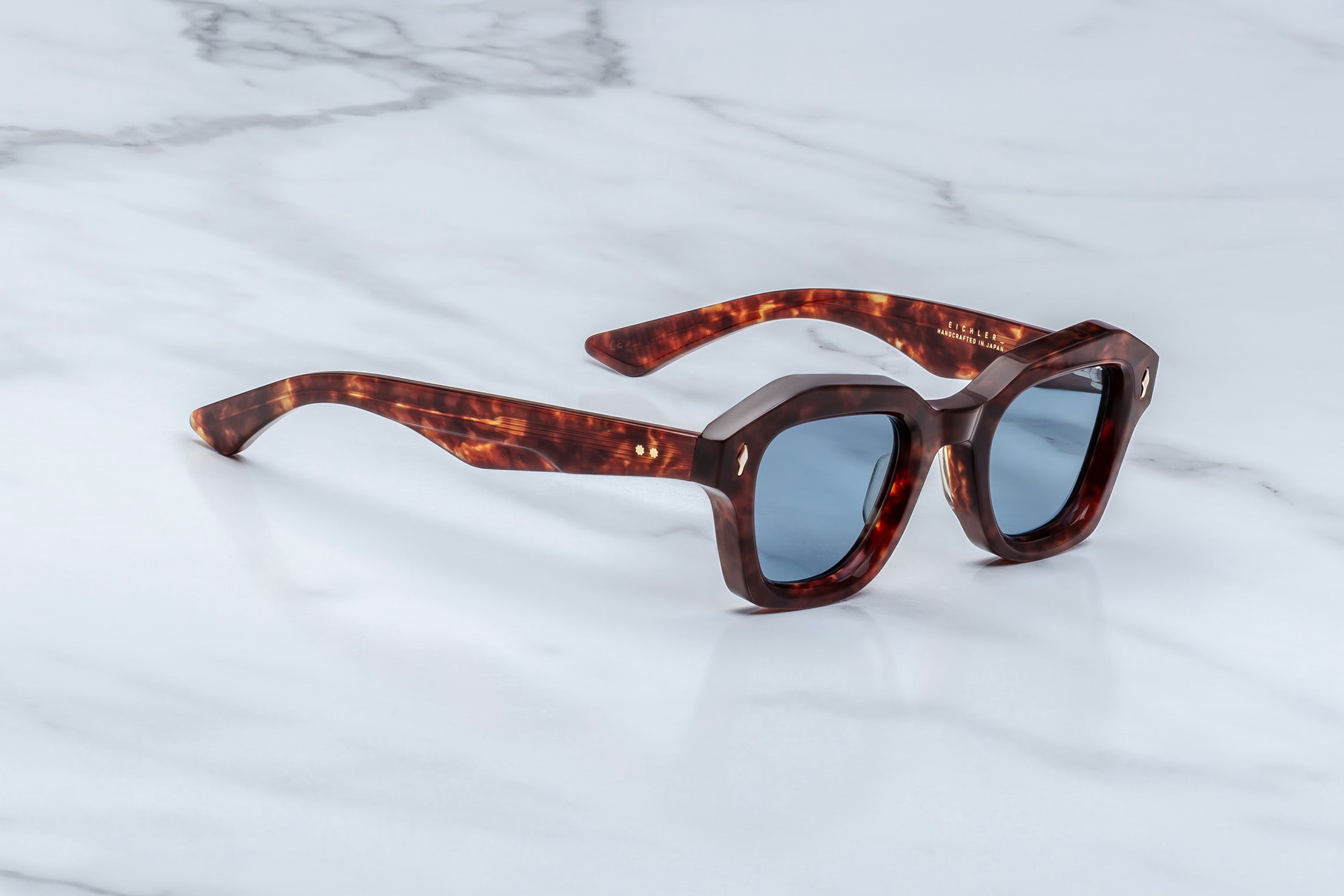 Sunglasses with tortoiseshell frame on a marble surface