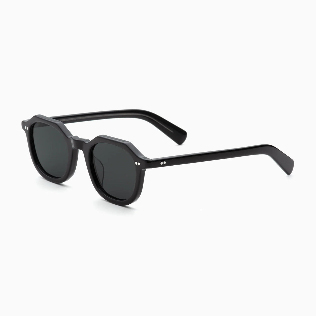 The Akila Eira by Akila features black sunglasses with round, subtly hexagonal lenses and thick, straight arms that channel a mid-century French crown panto aesthetic. These frames blend timeless elegance with a bold, squared silhouette eyeglasses design and are displayed on a white background.