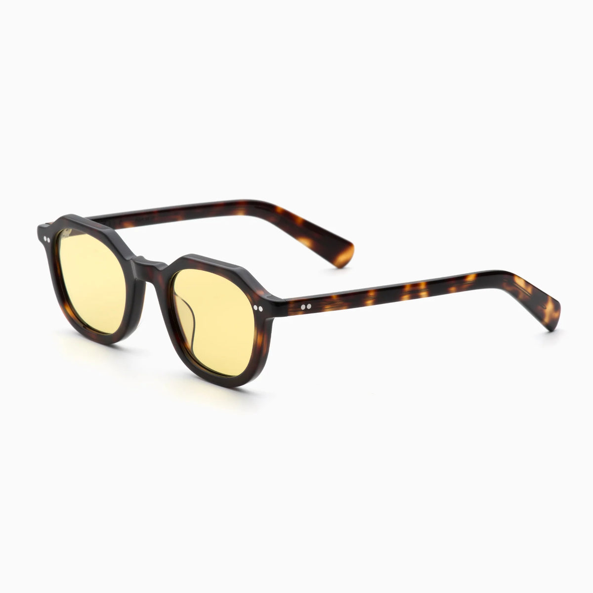 The Akila Eira sunglasses by Akila feature a tortoiseshell pattern with yellow-tinted lenses, showcasing a thick geometric frame and straight arms in a squared silhouette eyeglasses style, set against a white background.