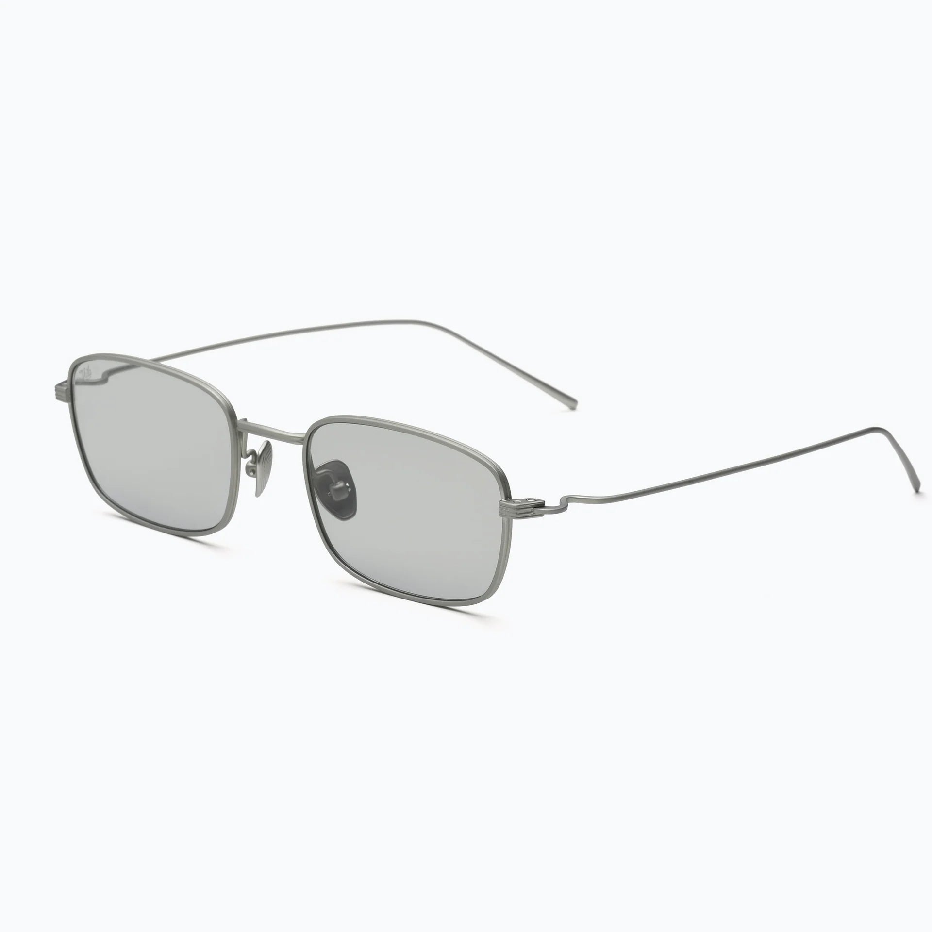 Silver wire-frame sunglasses with light grey tinted lenses, adjustable nose pads, and slim curved temples shown at an angled side view on a white background.