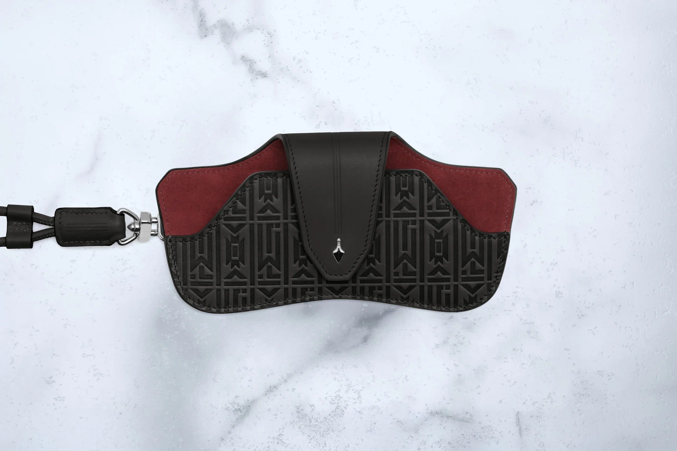 Black and red eyeglass case on a white marble background