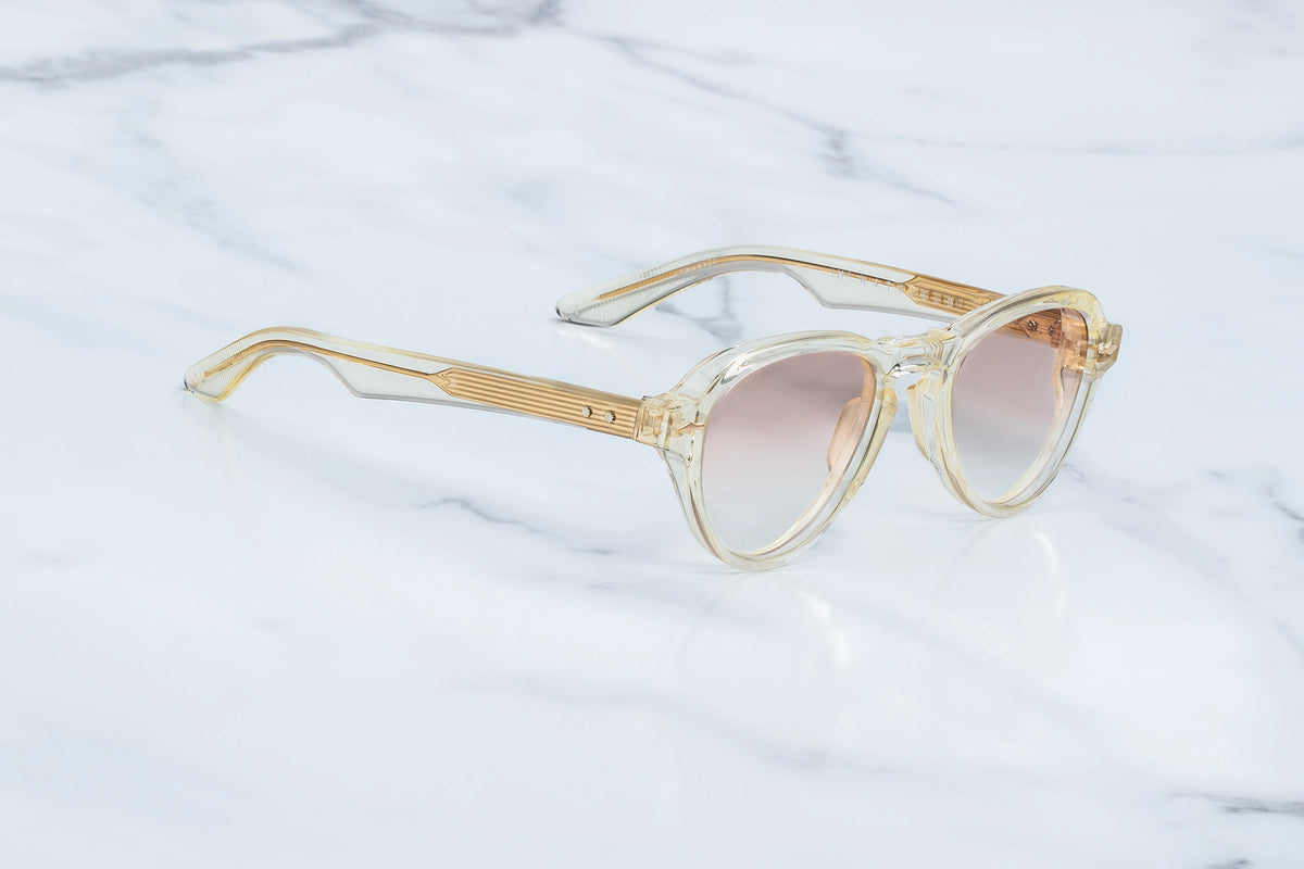 Jacques Marie Mage Hatfield clear-framed glasses with a prominent brow bridge and custom photochromic lenses that provide UV protection.