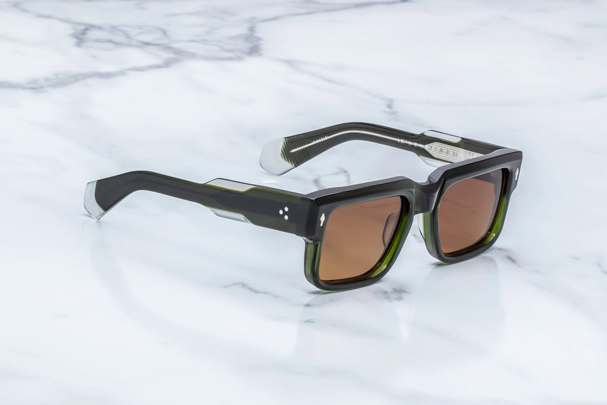 Jacques Marie Mage Hemmings rectangular sunglasses with thick black frames, olive green inner rims, and brown lenses, offering a sophisticated take on 60s-inspired spectacles.