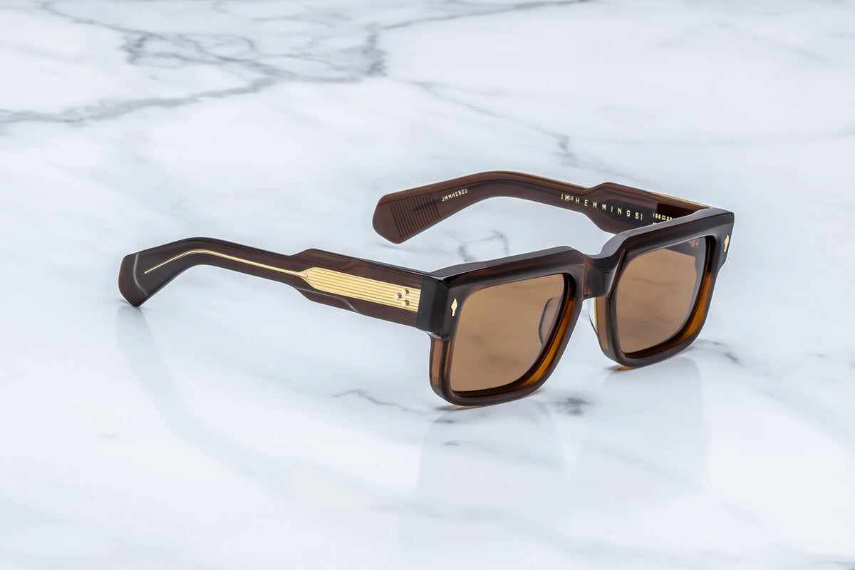 Jacques Marie Mage Hemmings rectangular brown sunglasses with thick, 60s-inspired frames and gold-toned metal detailing on the temples.