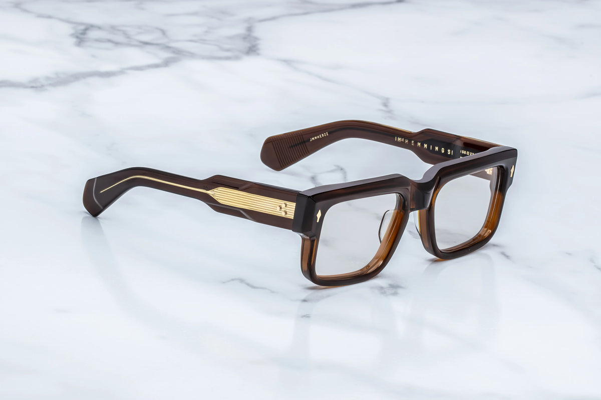 Sophisticated brown rectangular Jacques Marie Mage Hemmings eyeglasses with thick rims and 60s-inspired gold metal temple accents.