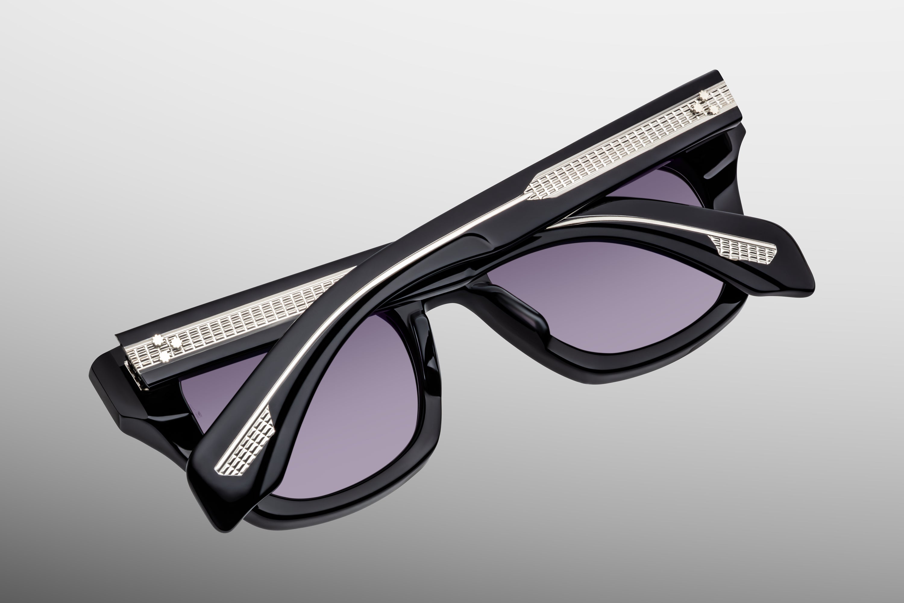 Exposed Temple silver Sunglasses with black frame and purple lenses on a gray background