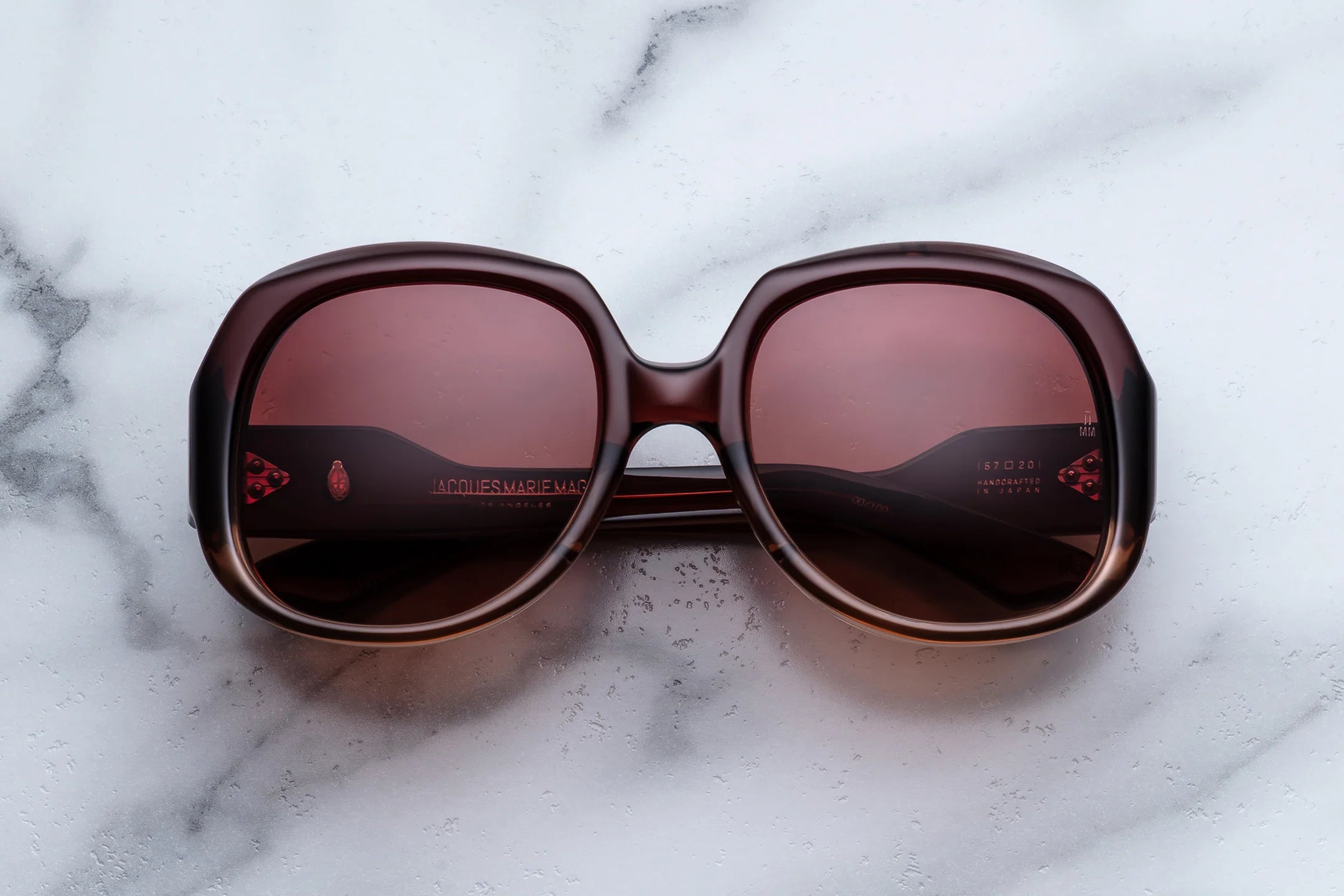 Large 70s Round Sunglasses with brown lenses on a marble surface