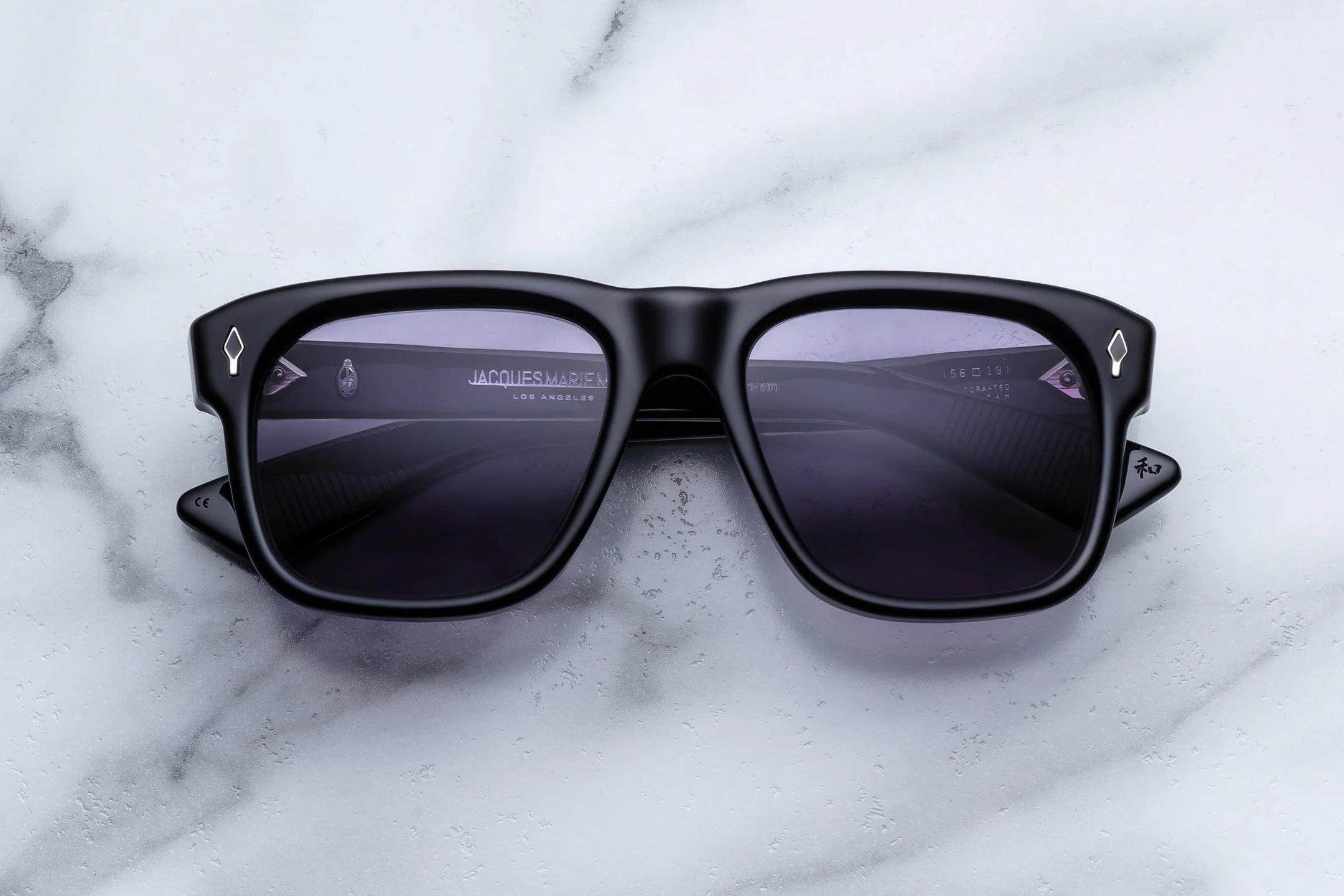 XL Large Black sunglasses with reflective lenses on a marble surface