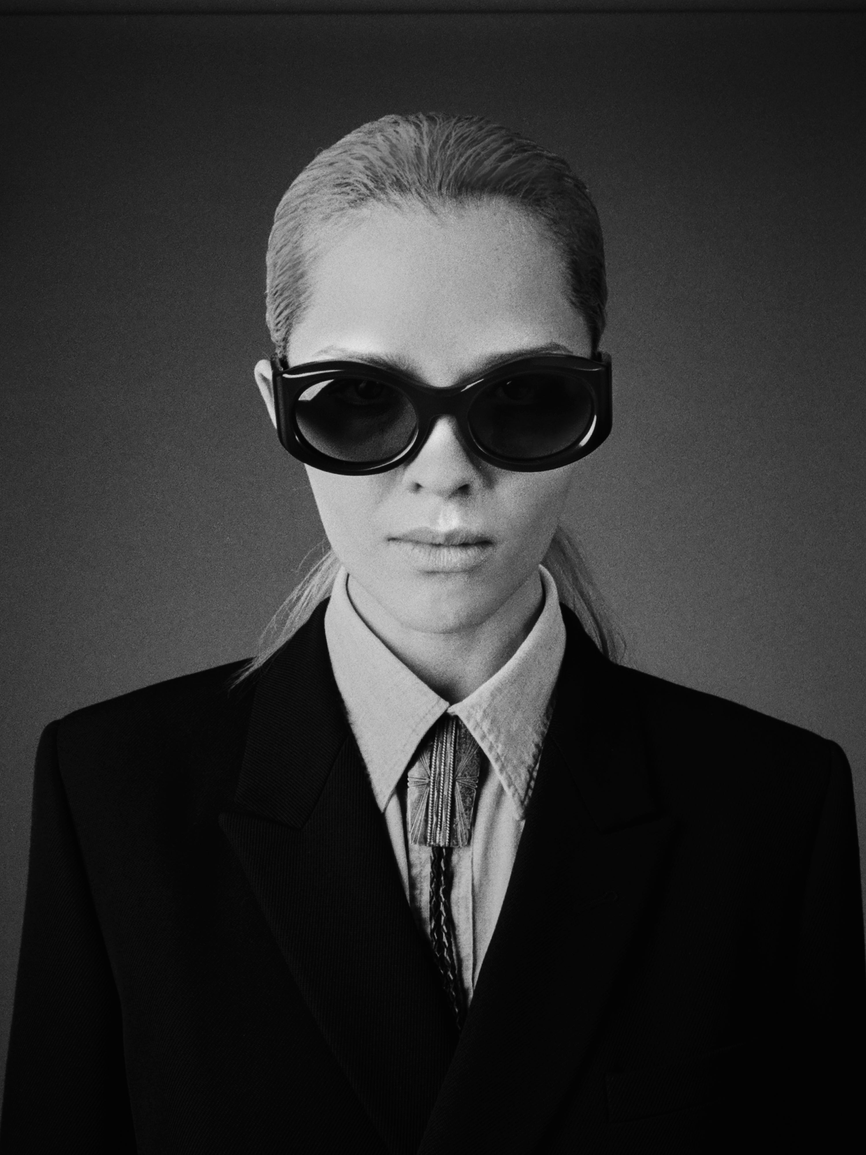 Person wearing a suit and JMM sunglasses in black and white