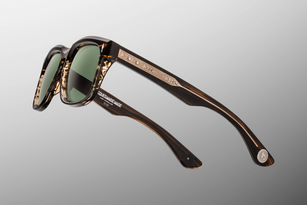 Jacques Marie Mage Yellowstone VII: Junction Butte In Lodgepole handcrafted acetate sunglasses in tortoiseshell with green polarized glass lenses, featuring engraved geometric patterns along the temples and branding on the inner frame.