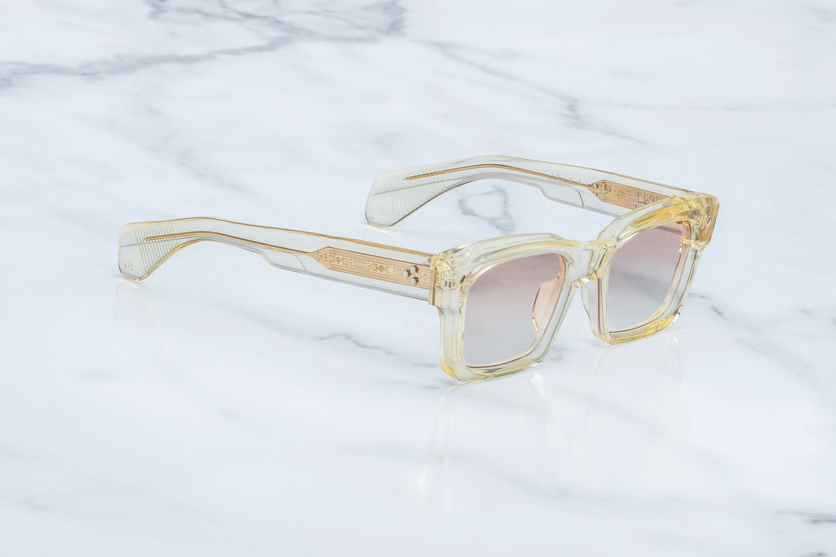Jacques Marie Mage Kaine square-framed sunglasses with translucent yellow frames and photochromic lenses, featuring decorative gold-toned detailing on the temples for UV protection.