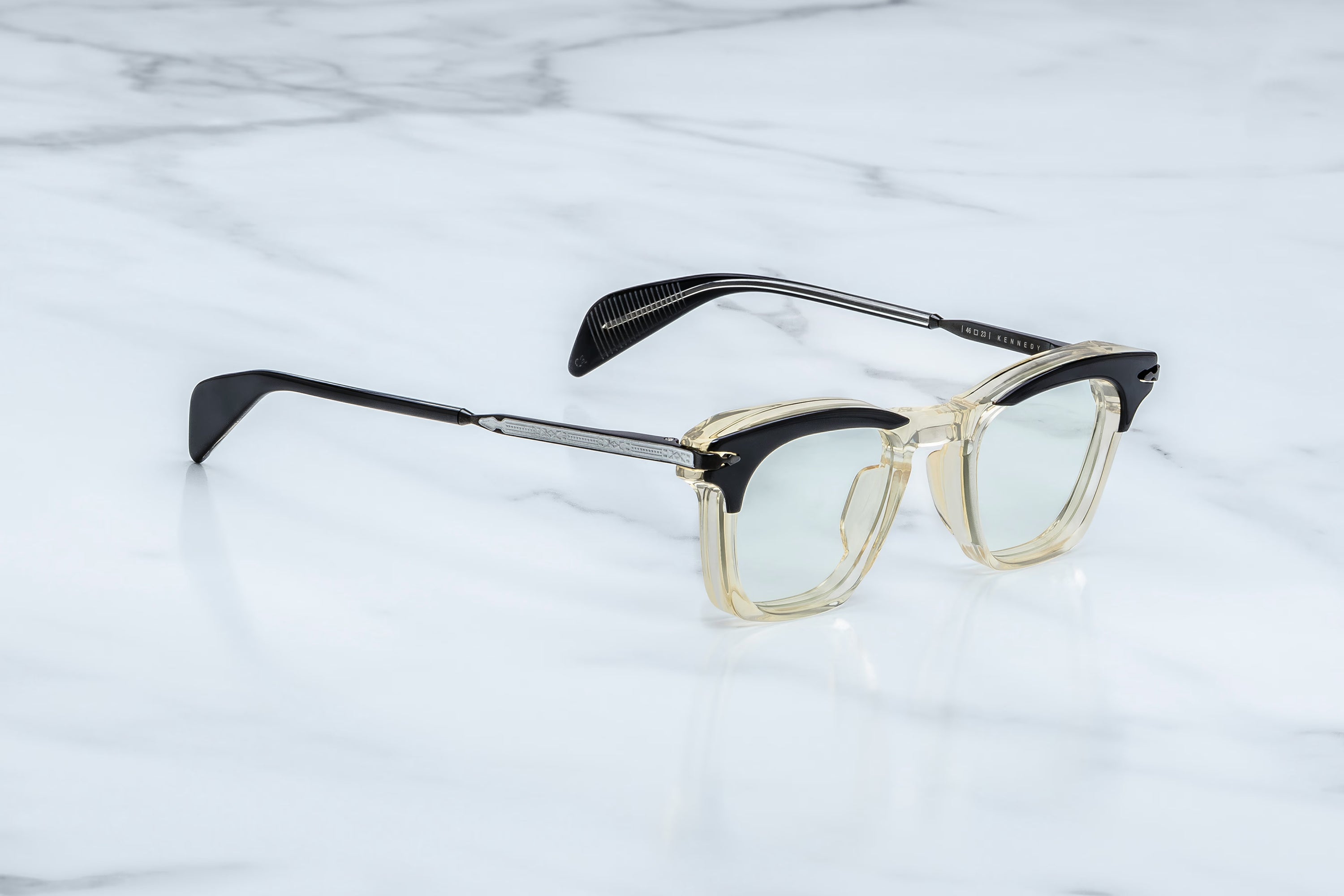 Eyeglasses with black and gold frame on a marble surface